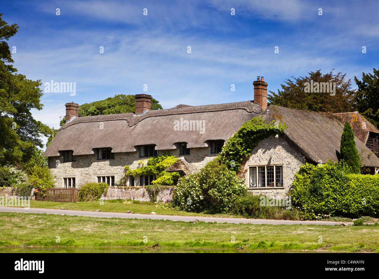 Bella e antica casa indipendente con tetto di paglia di cottage di campagna nel villaggio di Ashmore, Dorset, Inghilterra, Regno Unito in estate Foto Stock