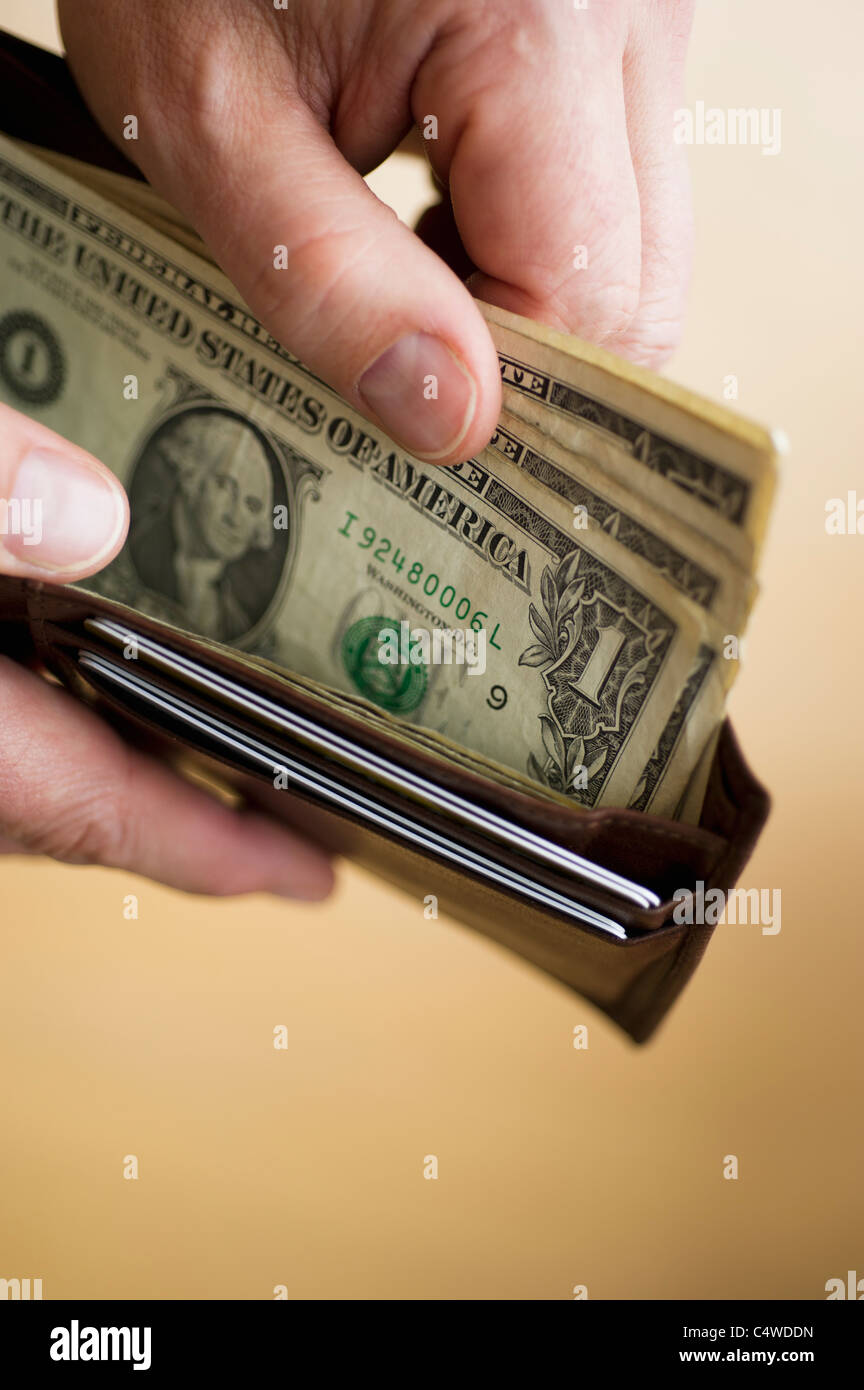 Close-up di uomo di mani portafoglio con banconote di dollari Foto Stock
