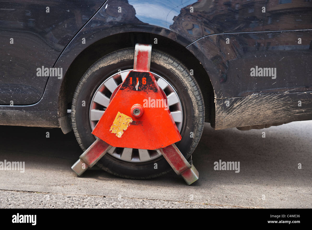 Ein Auto Parkverbot im ist mit einer Parkkralle gesichert | un auto nel parcheggio zona di divieto è fissato con un morsetto di bloccaggio di ruota. Foto Stock