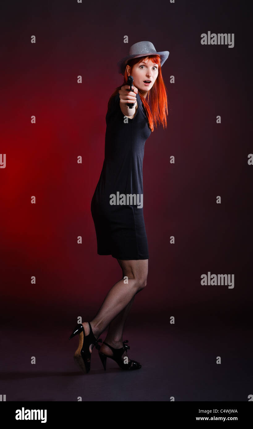 Crazy donna con pistola scappare, sfondo rosso Foto Stock