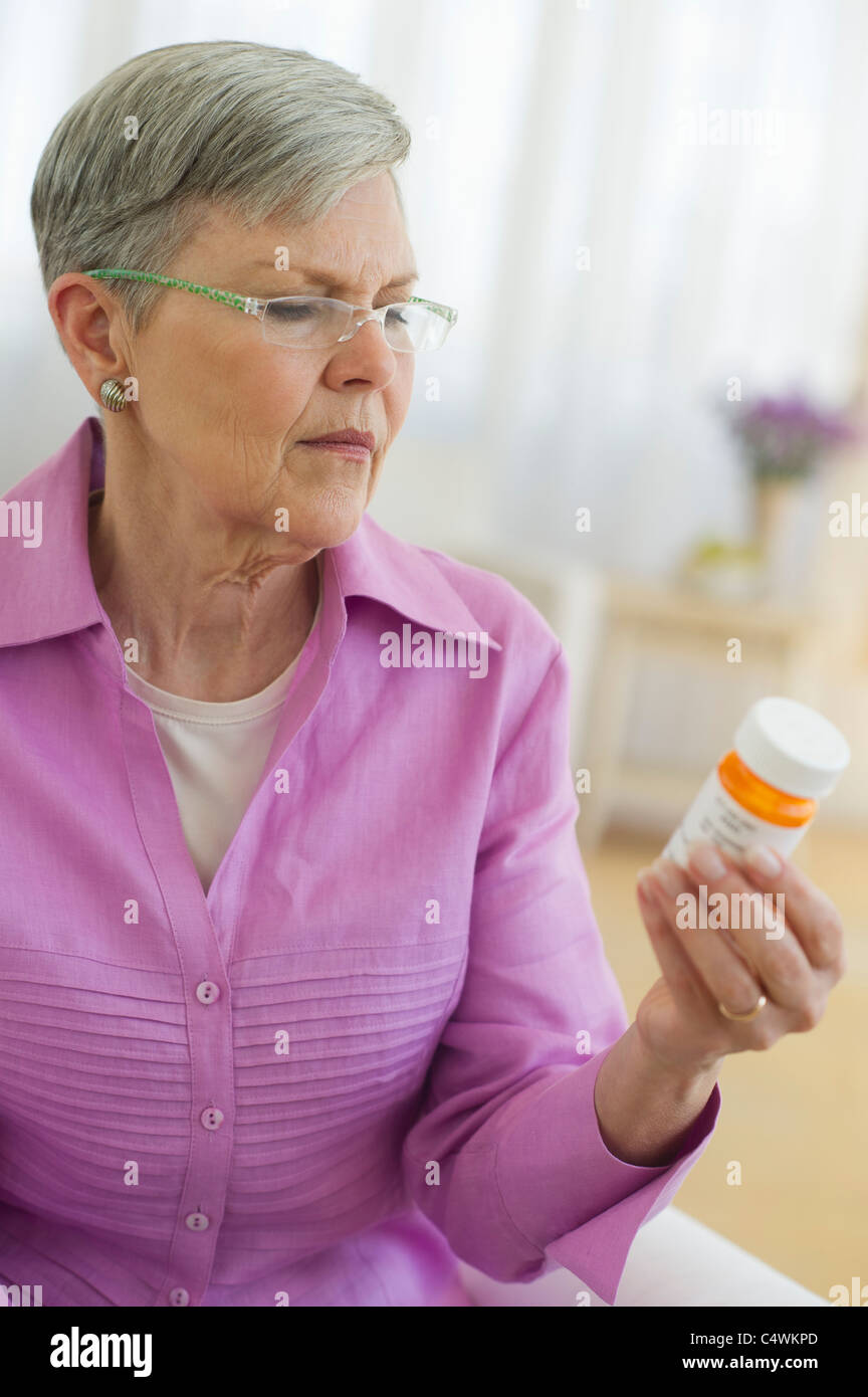 Stati Uniti d'America, New Jersey, Jersey City, Senior donna che guarda la pillola bottiglia Foto Stock