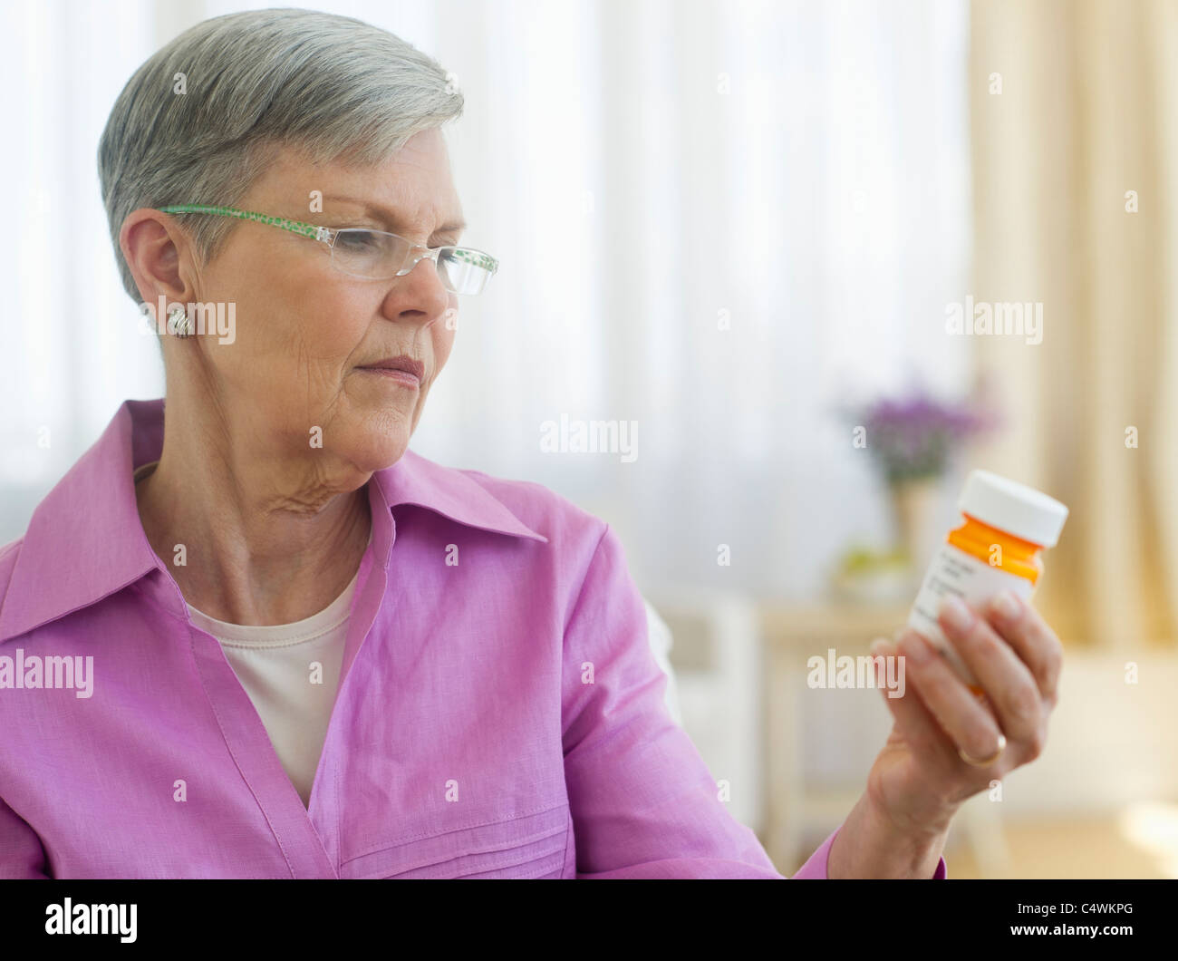 Stati Uniti d'America, New Jersey, Jersey City, Senior donna che guarda la pillola bottiglia Foto Stock