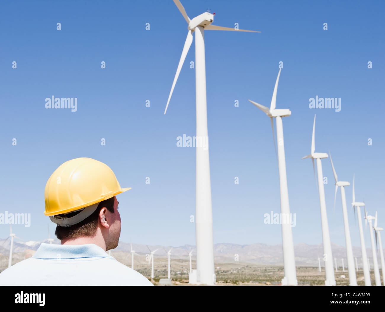 Stati Uniti, California, Palm Springs, Coachella Valley, San Gorgonio Pass, uomo in hard hat guardando le turbine eoliche Foto Stock