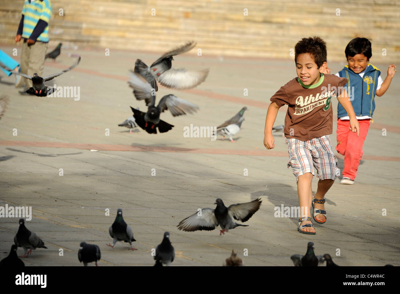 I Bambini a caccia di piccioni in Piazza centrale nella città di Fusagasuga quaranta miglia a sud-ovest della capitale Bogotà, Colombia. Foto Stock