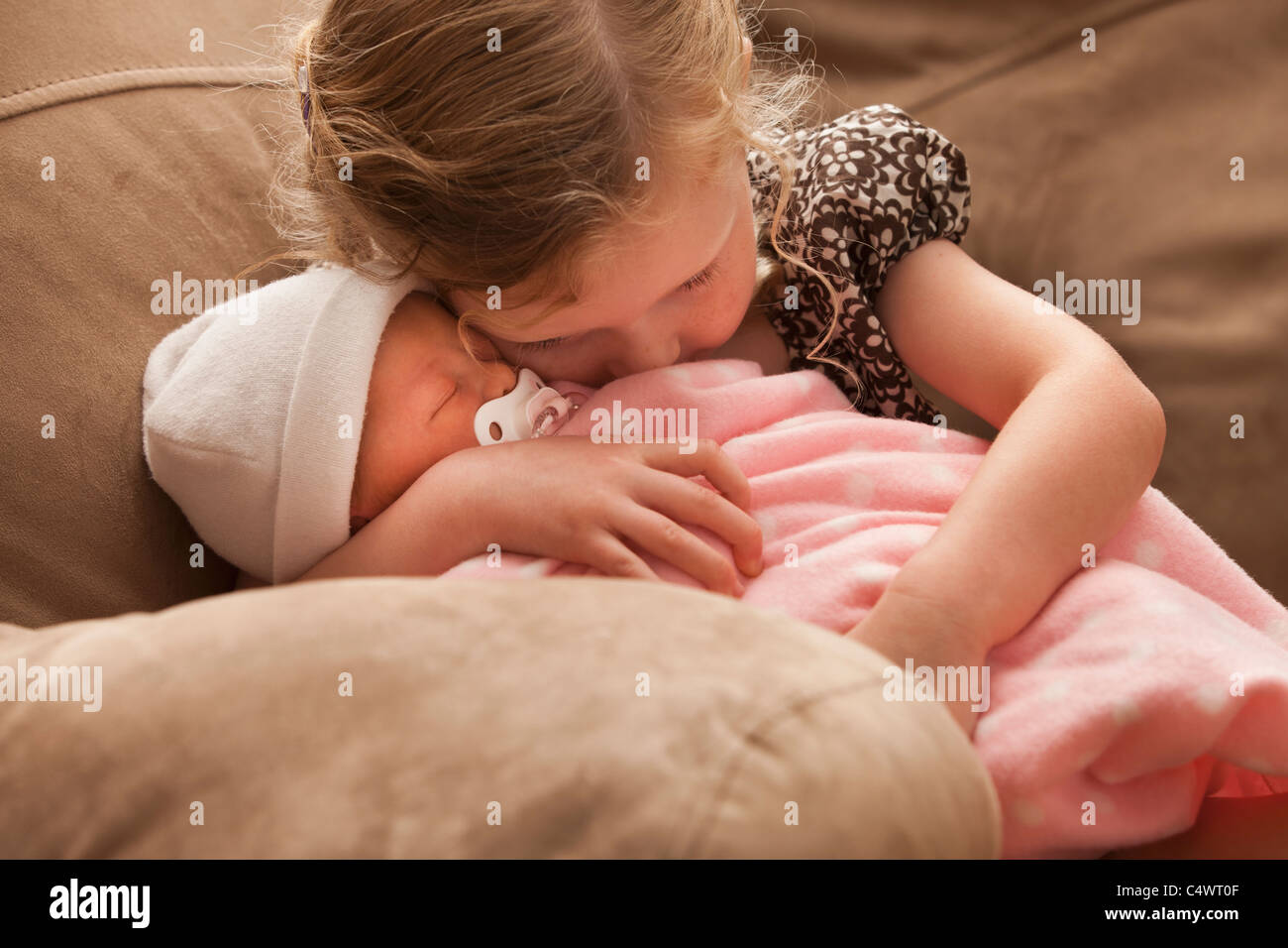 Stati Uniti d'America,Utah,Lehi,ragazza (2-3) abbracciando la sorella del bambino sul divano Foto Stock