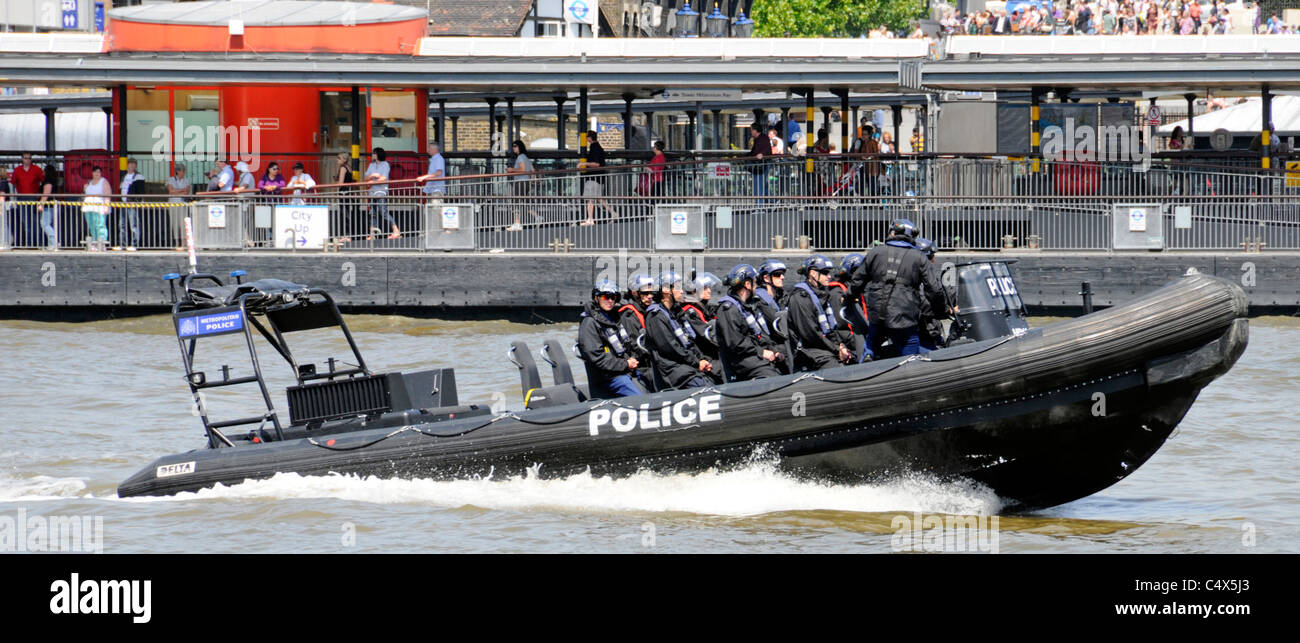 La Metropolitan Police ad alta velocità barca rigida gonfiabile e la squadra di polizia torre passando il molo sul Fiume Tamigi Foto Stock