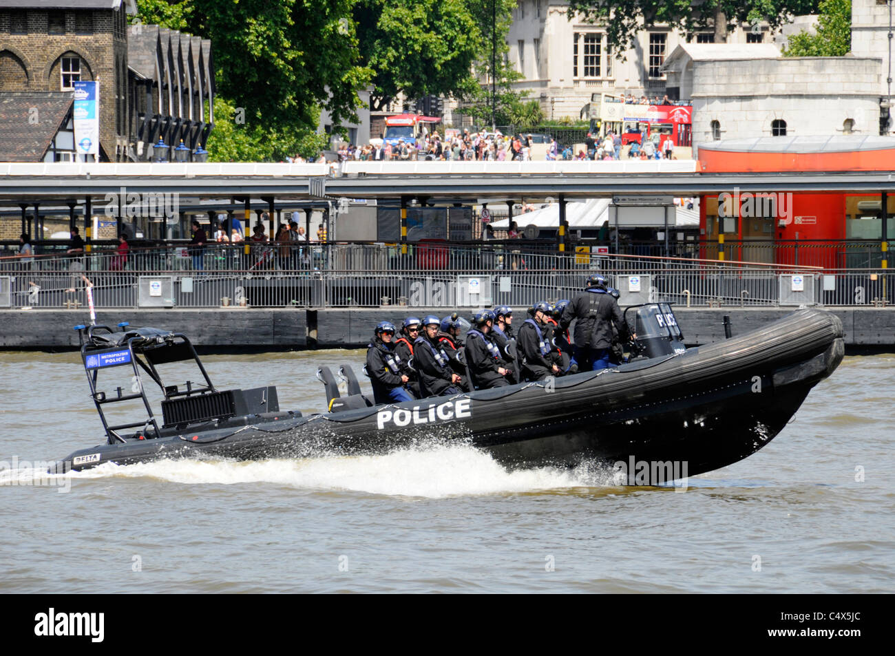 La Metropolitan Police ad alta velocità barca rigida gonfiabile e la squadra di polizia torre passando il molo sul Fiume Tamigi Foto Stock