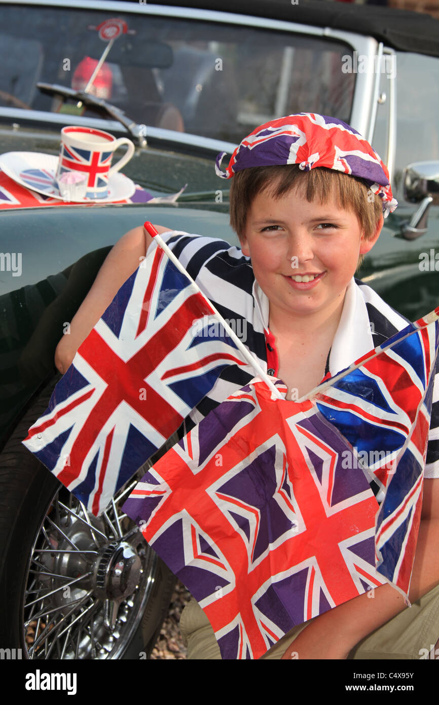 Giovane ragazzo che sorride mentre adornata con Union Jack Flag e altri paraphernalia britannico. Foto Stock