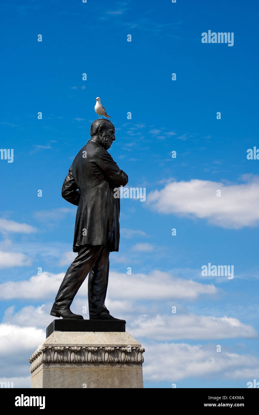 Un gabbiano si siede sulla testa di una statua di bronzo. Foto Stock