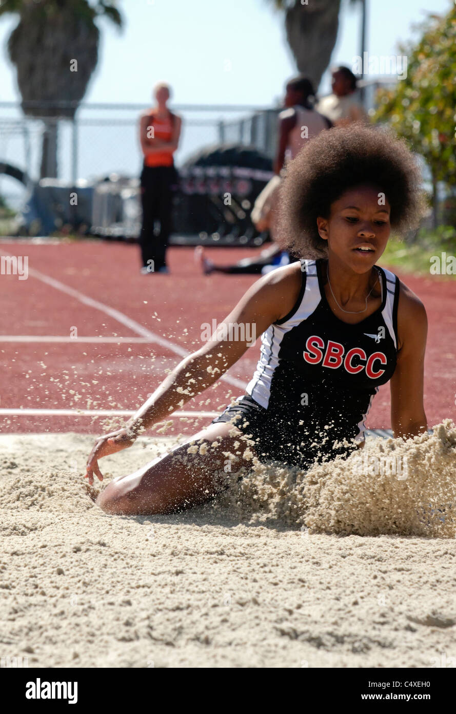 Salto in lungo tentativo da parte di atleta femminile durante una traccia e il campo event Foto Stock