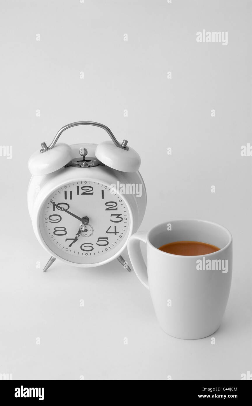 Sveglia e tazza da caffè su bianco Foto stock - Alamy