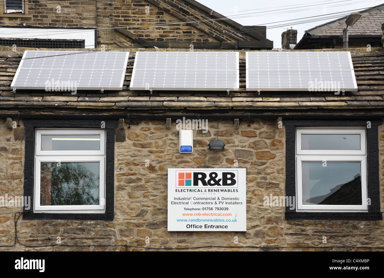 Una società che vende soluzioni rinnovabili con PV di pannelli solari sul tetto della propria sede a Skipton, nello Yorkshire, Inghilterra, Regno Unito Foto Stock