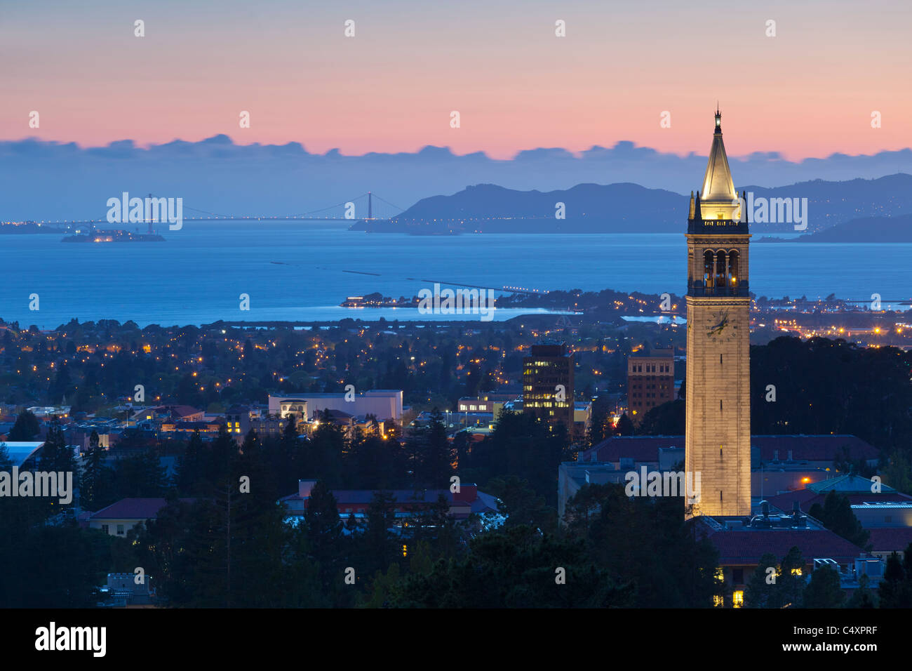 Sather Tower (a.k.a. Il Campanile) della UC Berkeley campus al tramonto con la Baia di San Francisco dietro di esso. Foto Stock