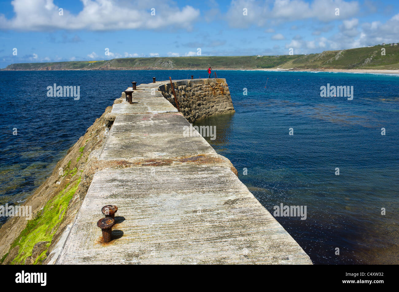 Un uomo in piedi sul lato della scogliera a Sennen in Cornovaglia. Foto Stock