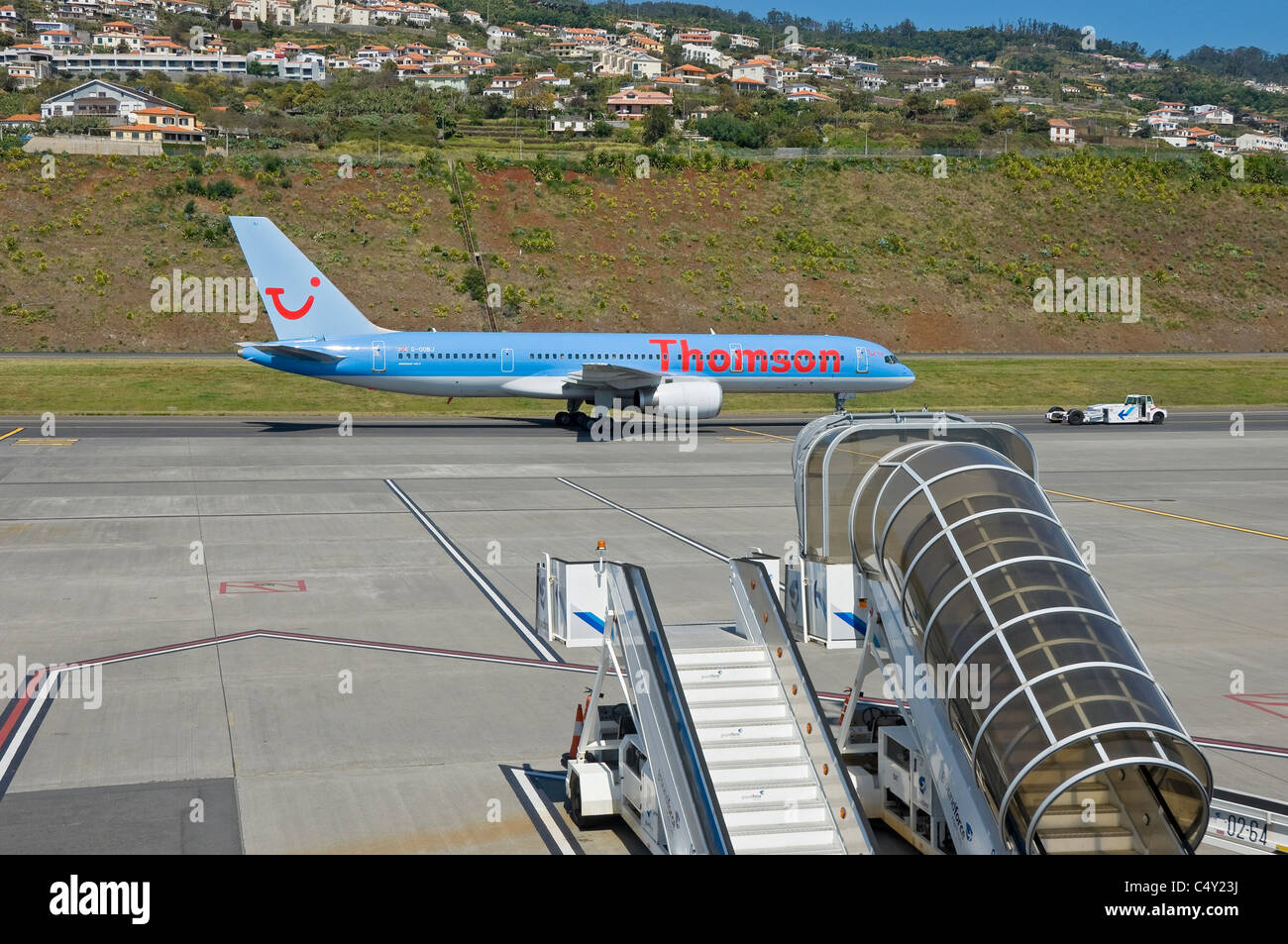 Scalini mobili e velivoli aerei Thomson su asfalto in Contesto all'aeroporto di Funchal Madeira Portogallo Europa dell'UE Foto Stock