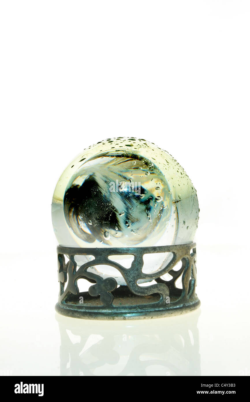 Scuro forme astratte in una sfera di cristallo coperto di goccioline di acqua Foto Stock