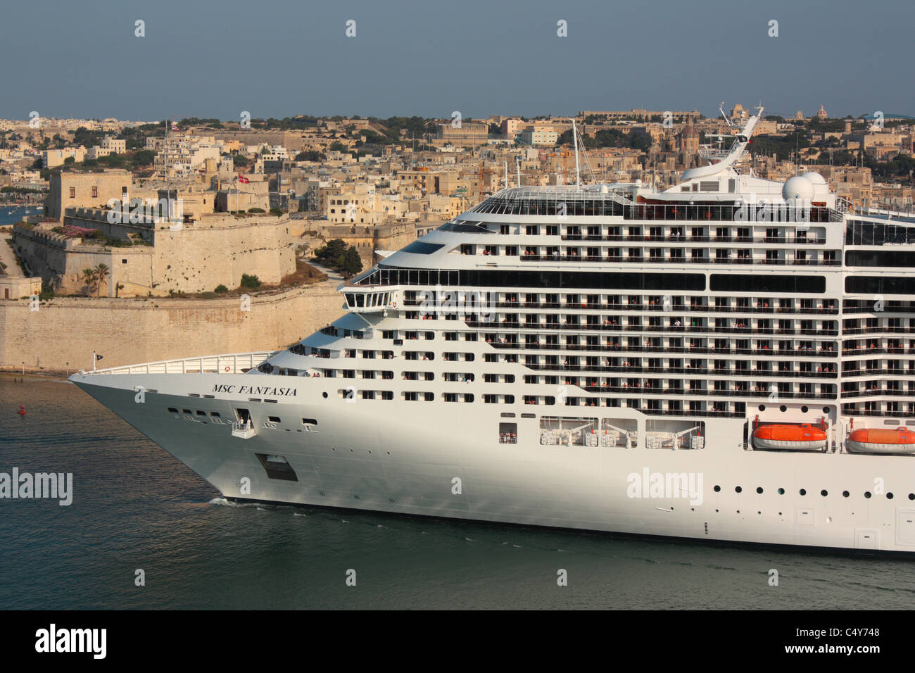 I viaggi di vacanza nel Mediterraneo. Close-up della nave da crociera MSC Fantasia in partenza da Malta il Grand Harbour, con il Forte Sant'Angelo a sinistra Foto Stock