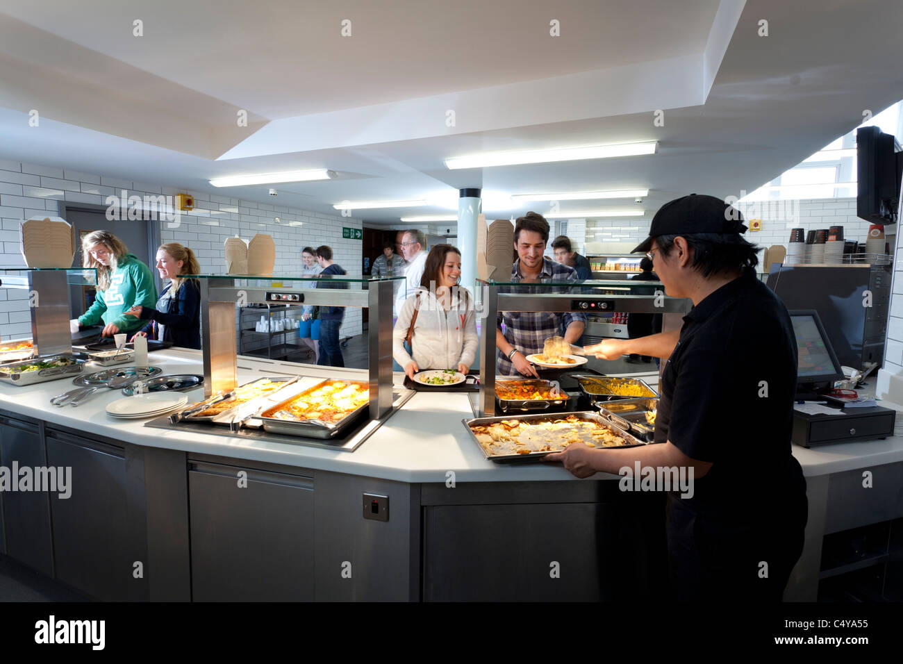 Gli studenti a tempo del pranzo Wantage Hall lettura studente universitario ristorante self service Foto Stock
