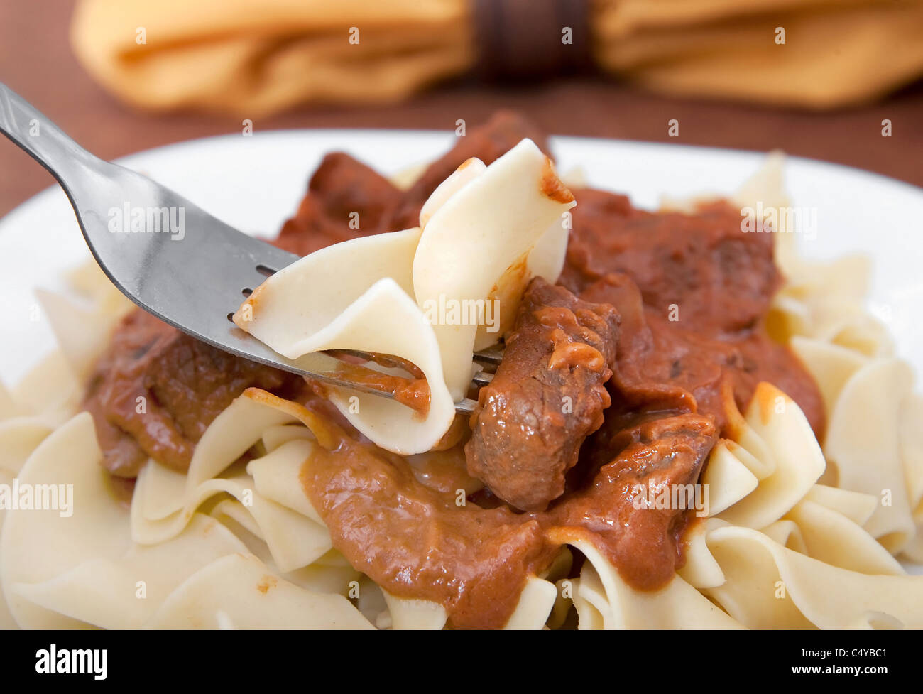 Un boccone di carne di manzo stroganoff su una forcella con tagliatelle Foto Stock