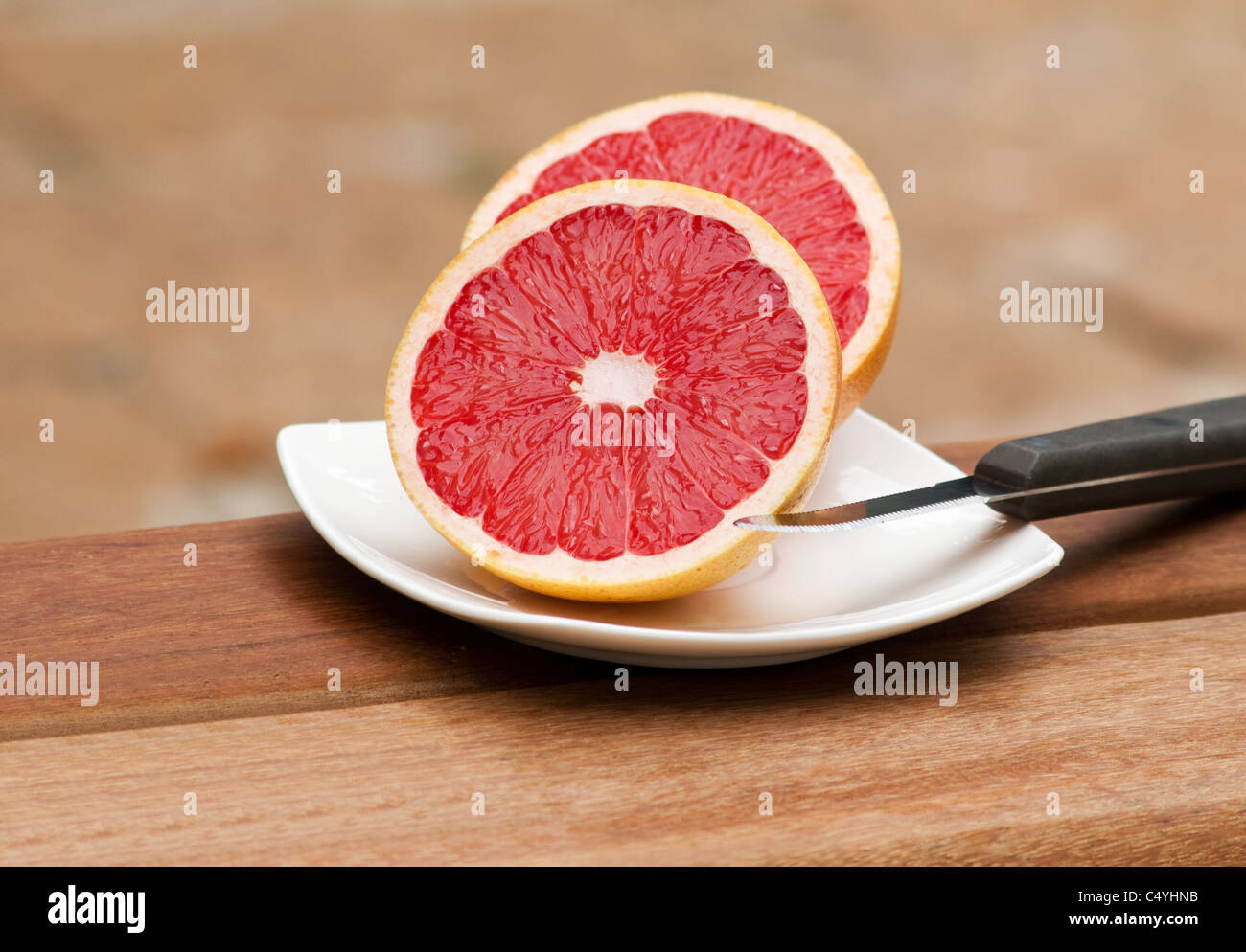 Pompelmo tagliato a metà sul piatto bianco Foto Stock