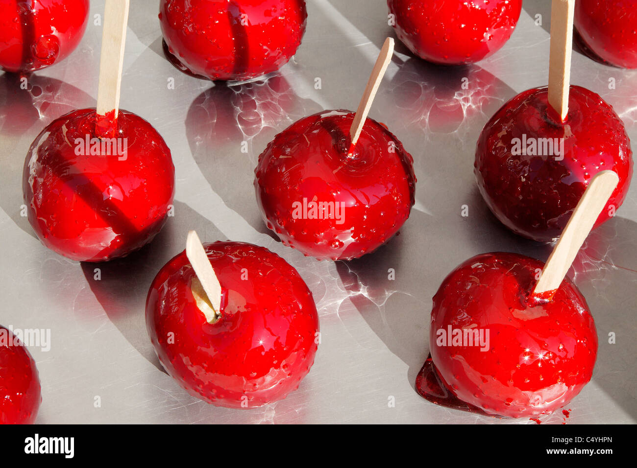 Un gruppo di rosso caramella mele su una superficie di metallo Foto Stock