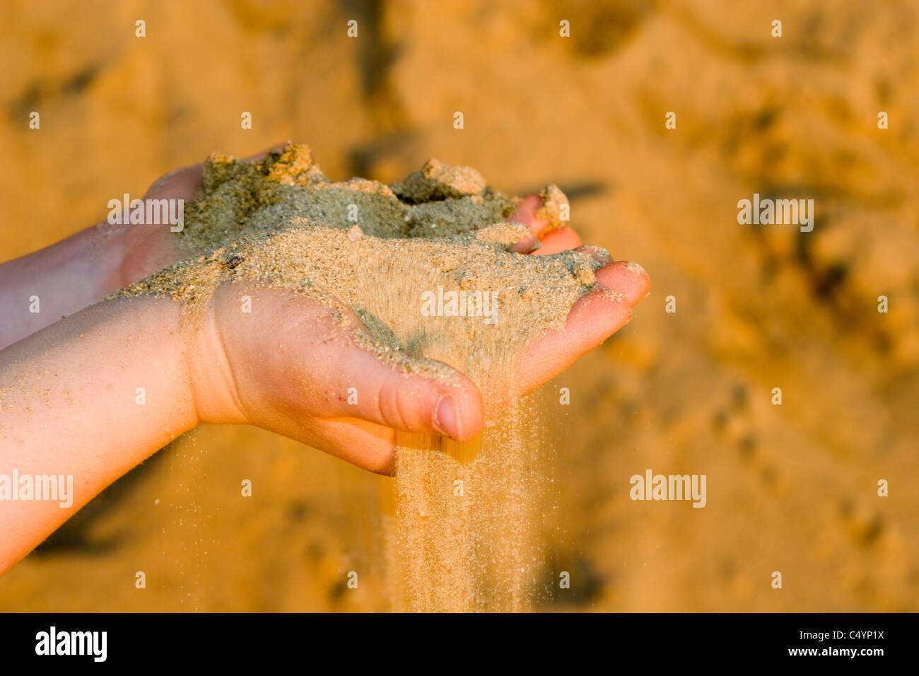 Le mani della bambina e la sabbia Foto Stock