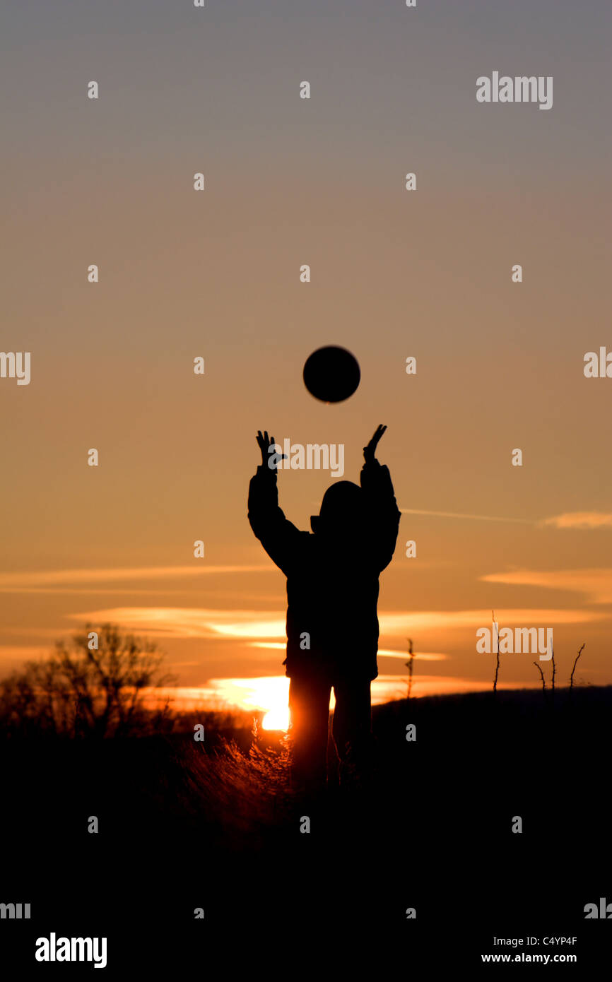 Gioco della bambina con la palla in sunset Foto Stock