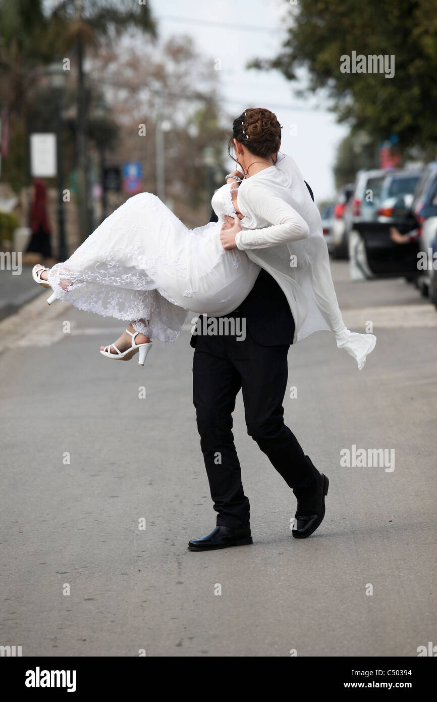 Tradizionale Matrimonio ebraico lo sposo porta sposa in strada Foto Stock