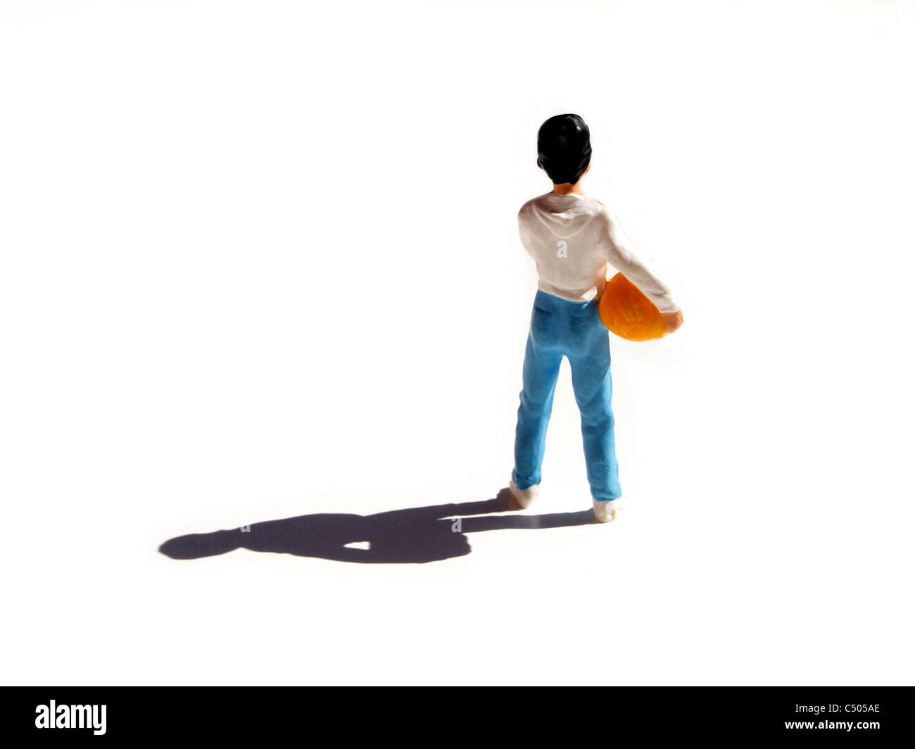 Figurina che rappresenta un giovane ragazzo con un pallone da calcio sotto il braccio - Vista posteriore Foto Stock