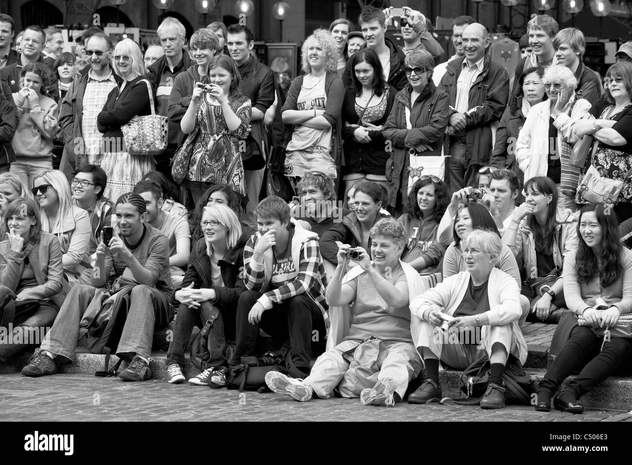 I turisti a guardare la strada animatori, Covent Garden di Londra, Inghilterra Foto Stock