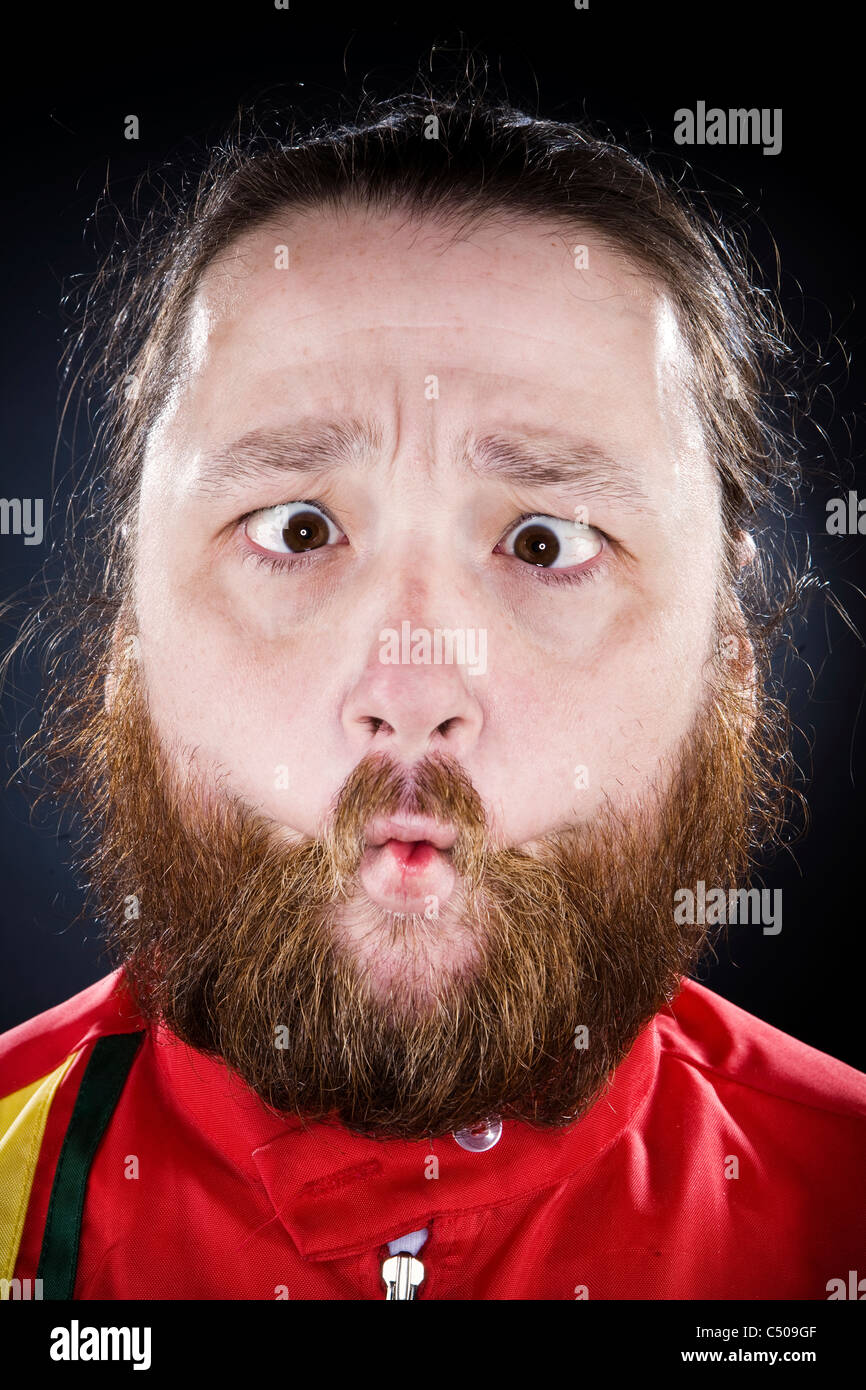 Uomo Barbuto raggrinzamenti la sua bocca Foto Stock