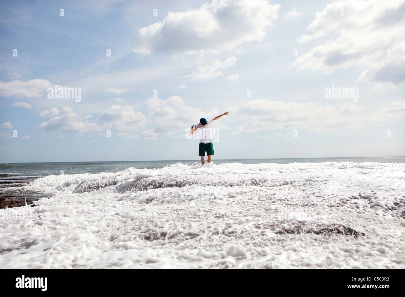 Uomo in piedi in oceano onde Foto Stock