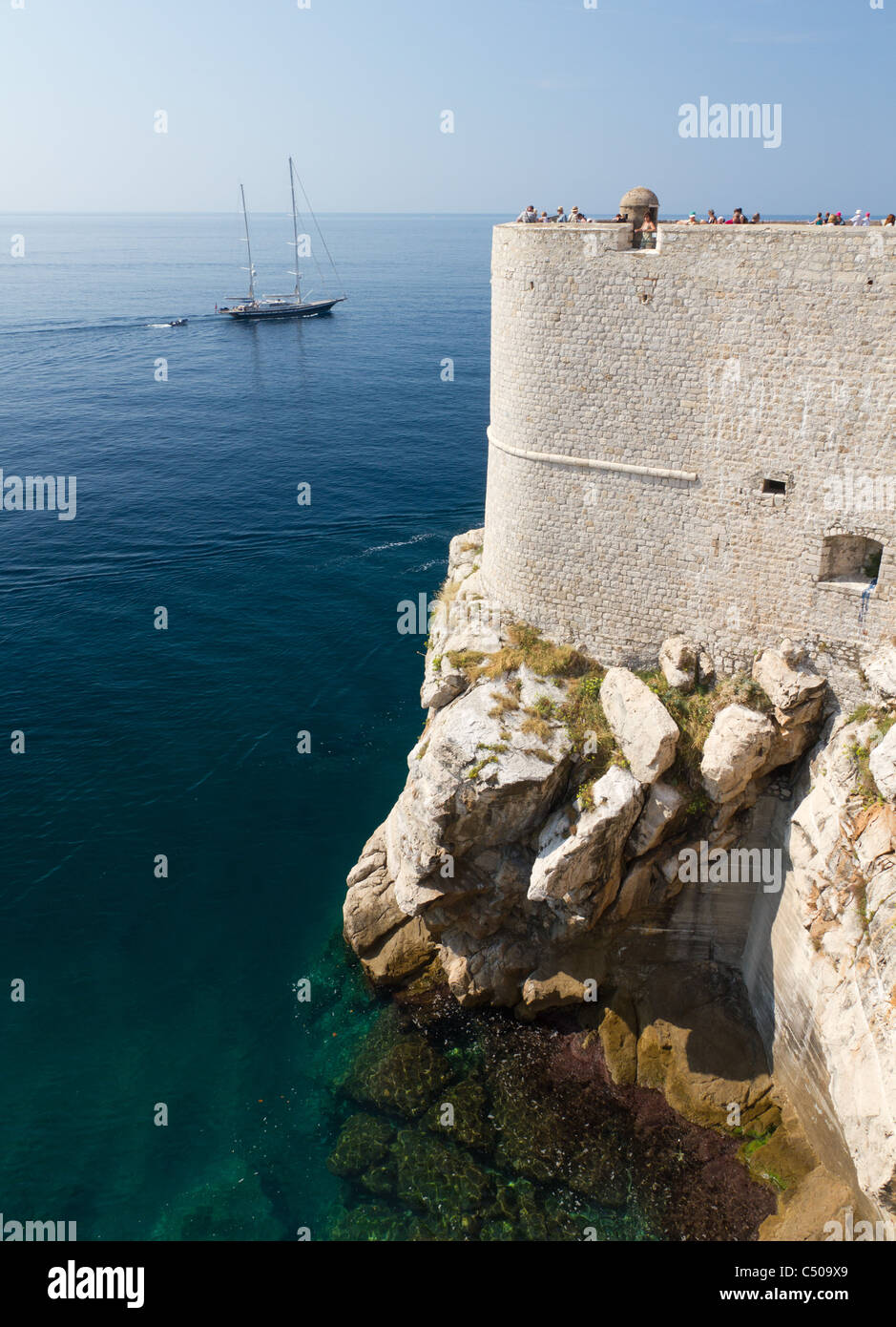 White forti mura della città con la torre di avvistamento costruita sulla spiaggia rocciosa di Dubrovnik, Croazia Foto Stock