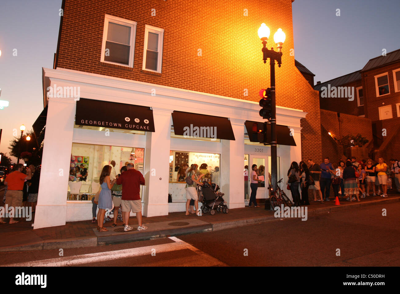 Persone in attesa in linea per Georgetown tortine Foto Stock