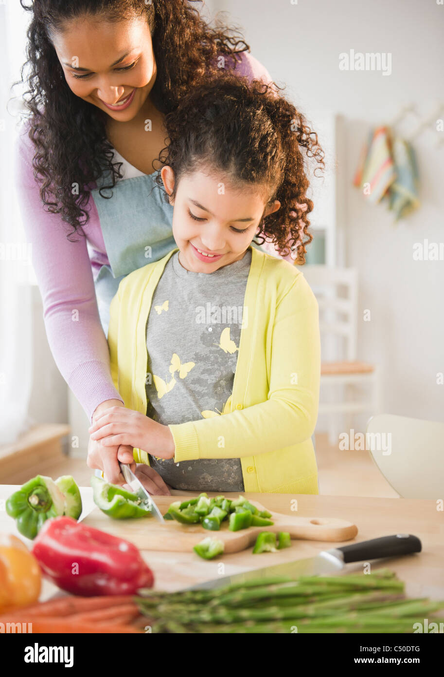 Madre e figlia tritare verdure insieme Foto Stock