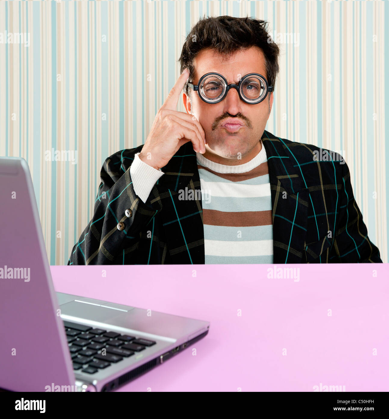 Nerd pensieroso Uomo con occhiali miope e stupida espressione alla ricerca  di una soluzione in computer laptop Foto stock - Alamy