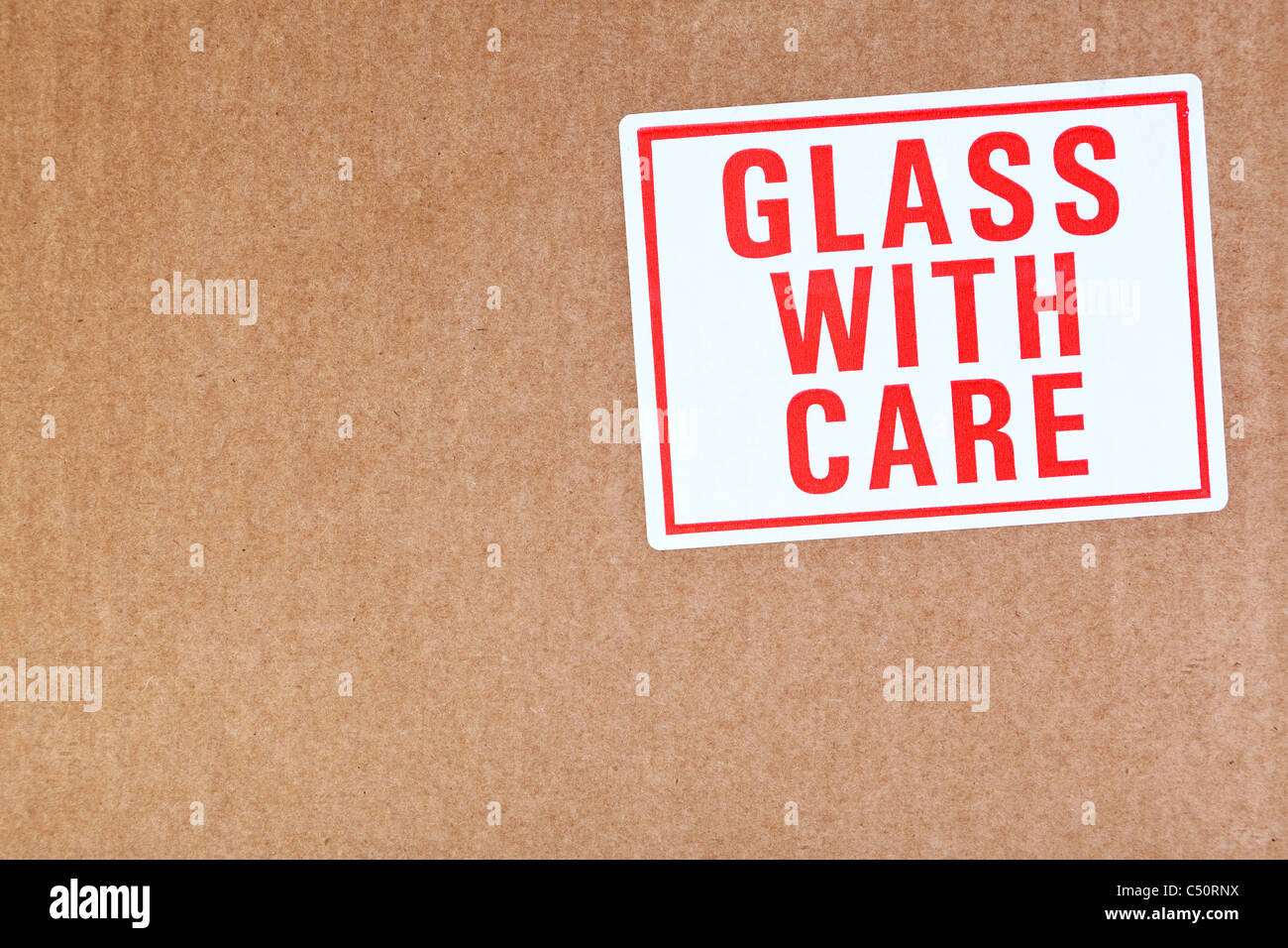 Foto di un vetro con adesivo di cura su un sfondo di cartone. Foto Stock