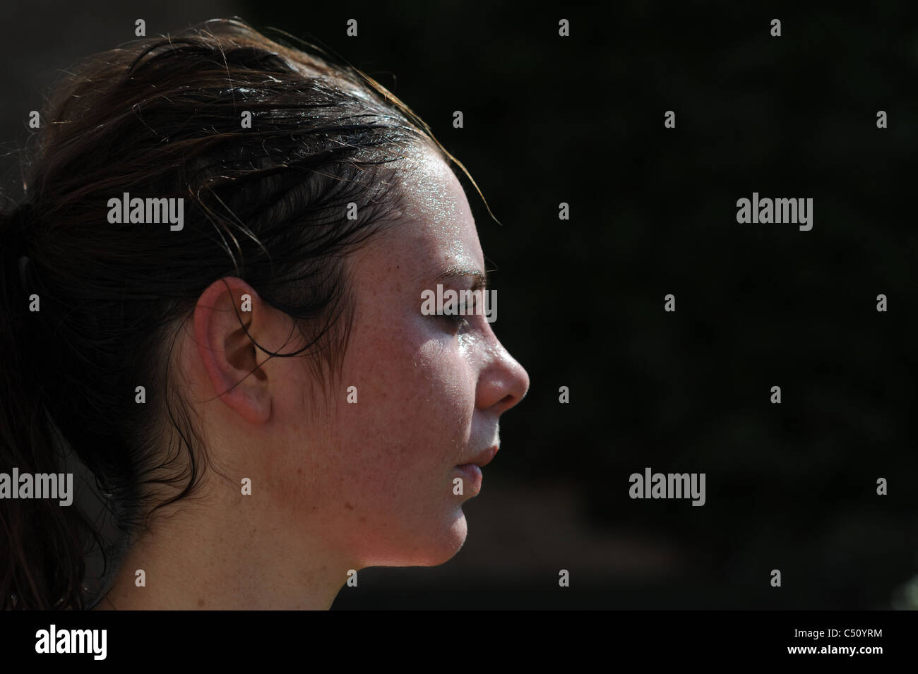 Giovane donna cercando accaldato con sudore sul forehaed dopo la corsa mattutina in temperatura calda Foto Stock