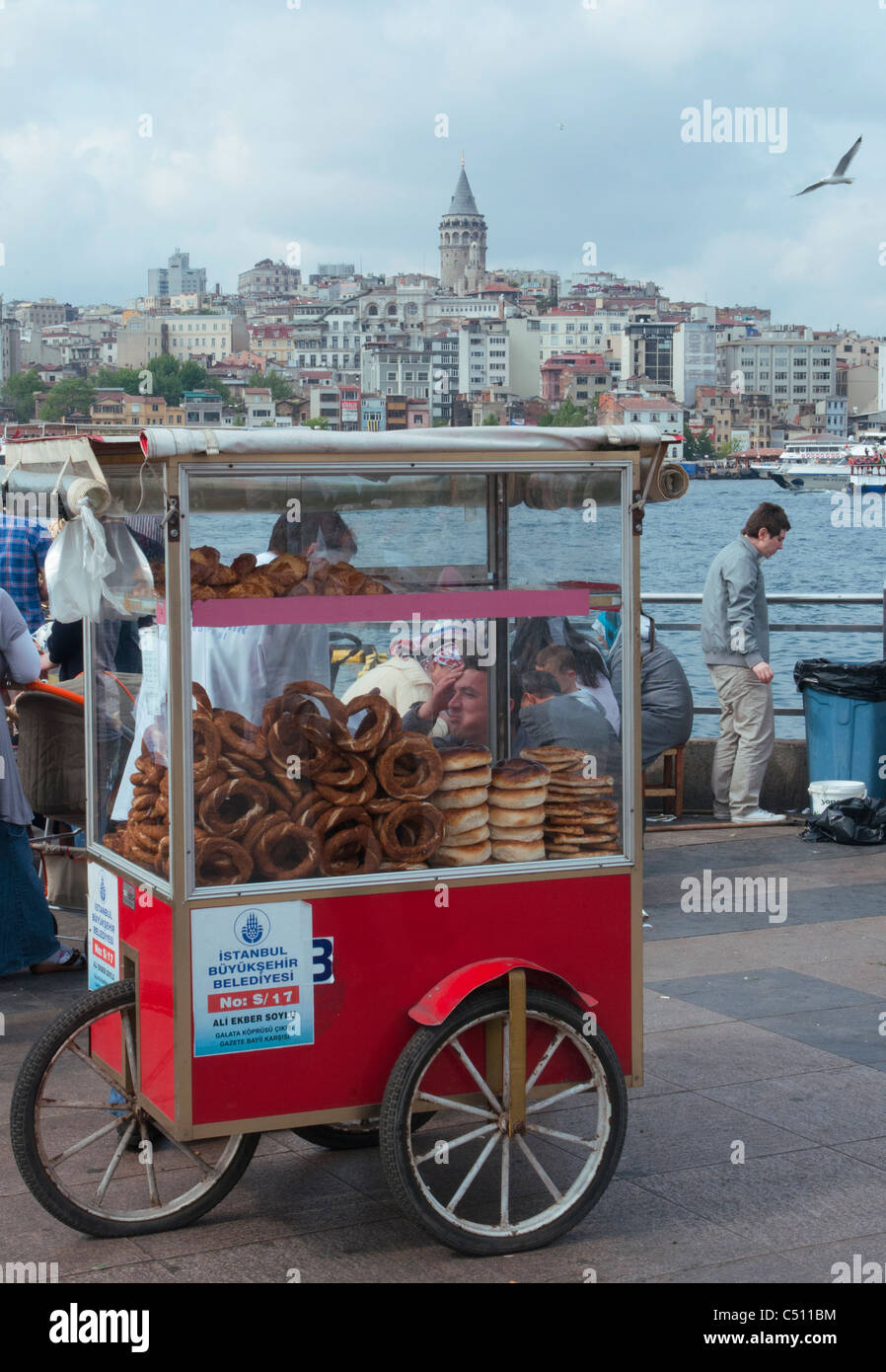 Un fornitore di pane al traghetto principale wharf a Eminönü, con la Torre di Galata al di là Foto Stock