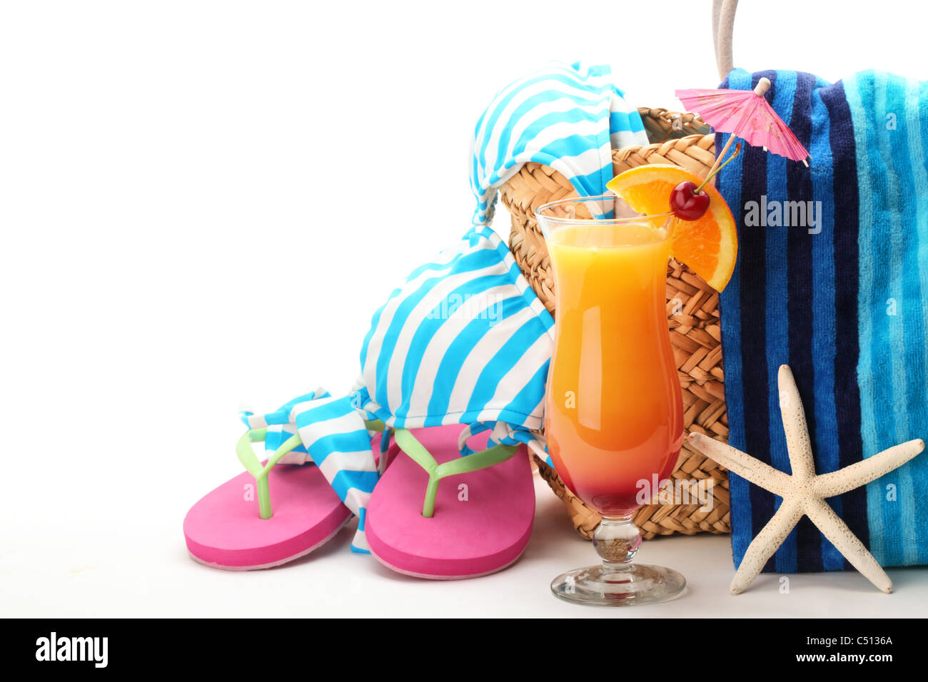 Gli elementi in spiaggia con il costume da bagno, asciugamano, ciabatte e un bicchiere di cocktail.isolati su sfondo bianco. Foto Stock