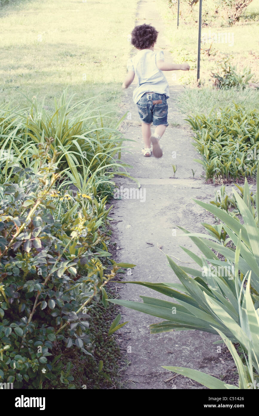Bambina in esecuzione sul percorso, vista posteriore Foto Stock
