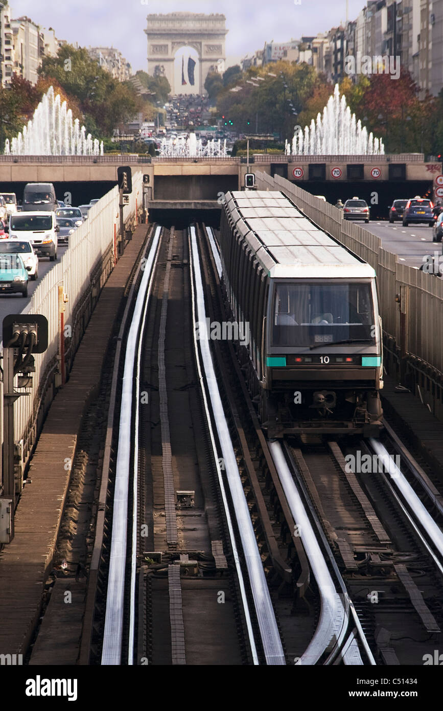 Treno della metropolitana in esecuzione su binario in città, Arc de Triomphe in background Foto Stock