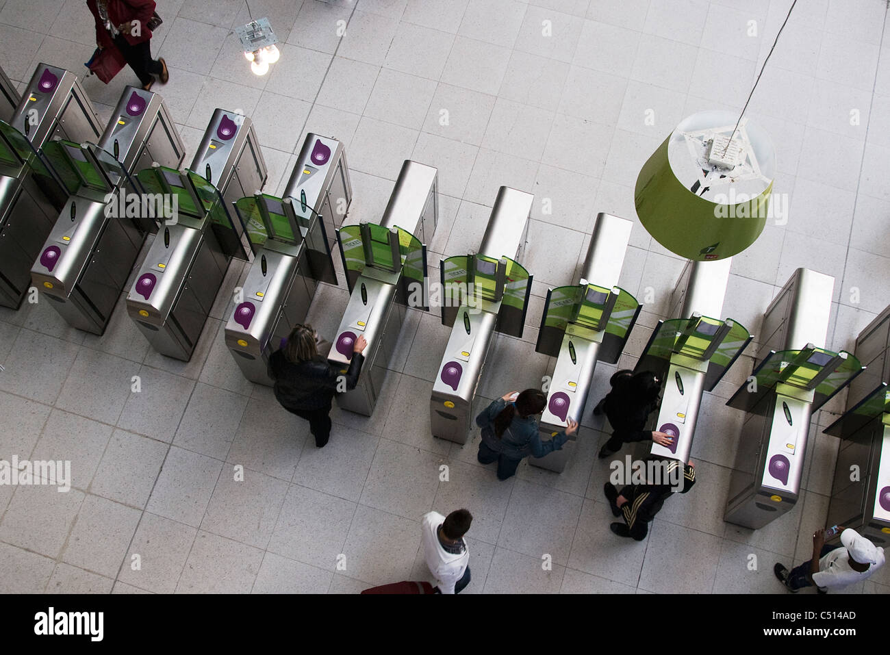 Persone che attraverso i tornelli nella stazione della metropolitana Foto Stock