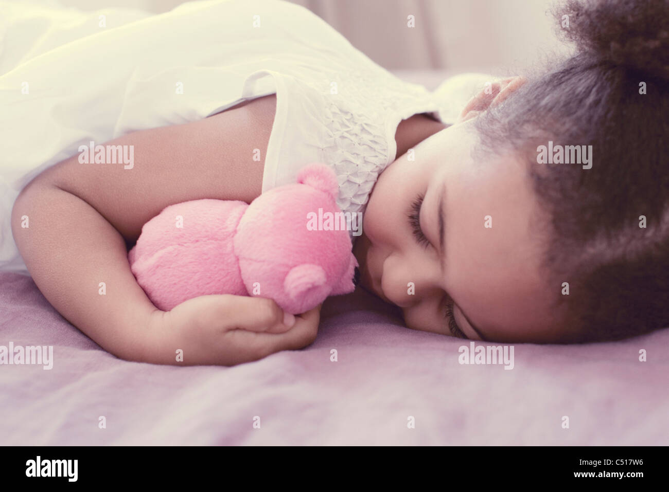 Piccola ragazza dorme con animali impagliati Foto Stock