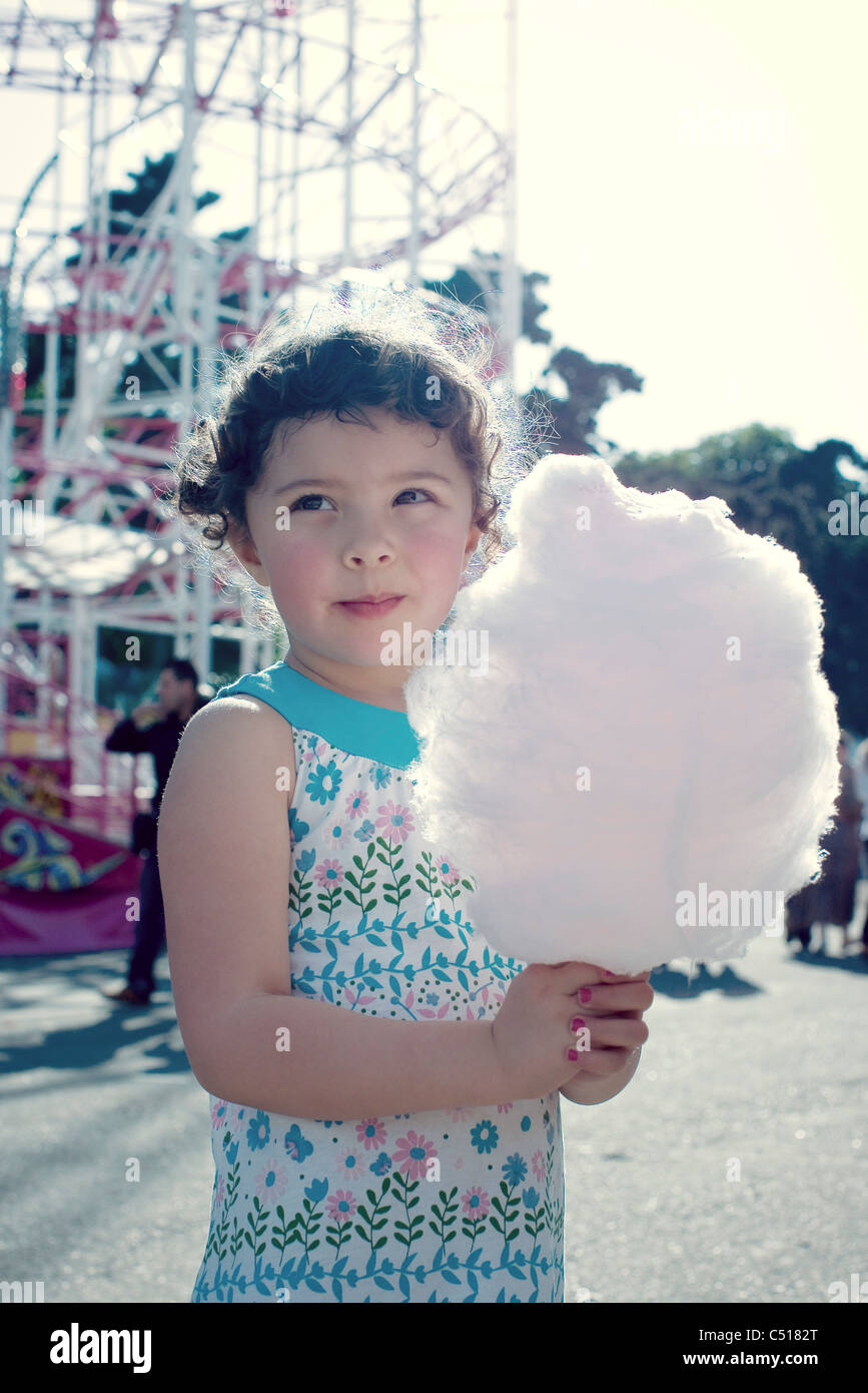 Little Girl holding caramella di cotone al fair, ritratto Foto Stock