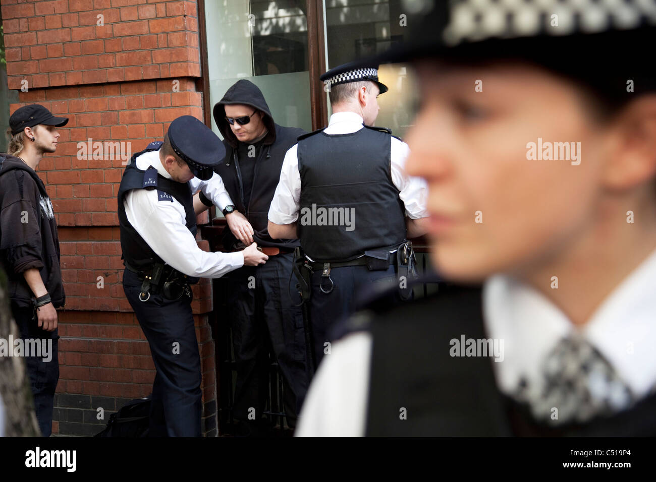 La polizia utilizzando i loro poteri di arresto e di ricerca durante lo sciopero generale del marzo nel centro di Londra. Foto Stock