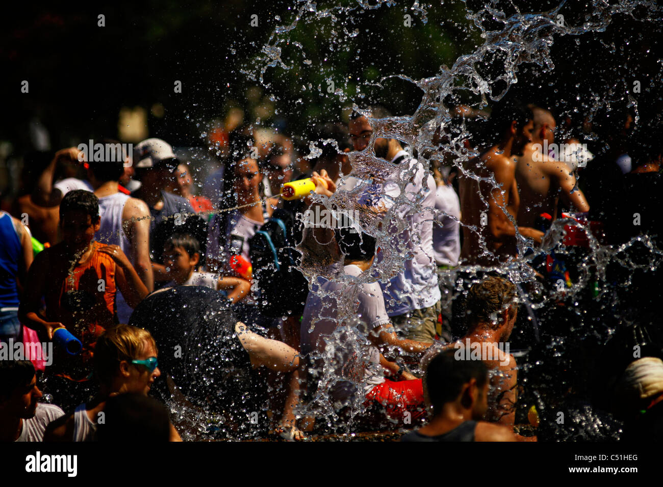 Giovani gaudenti ebraica spry acqua su ogni altro durante l'acqua annuale lotta in Rabin Square nel centro cittadino di Tel Aviv Israele Foto Stock