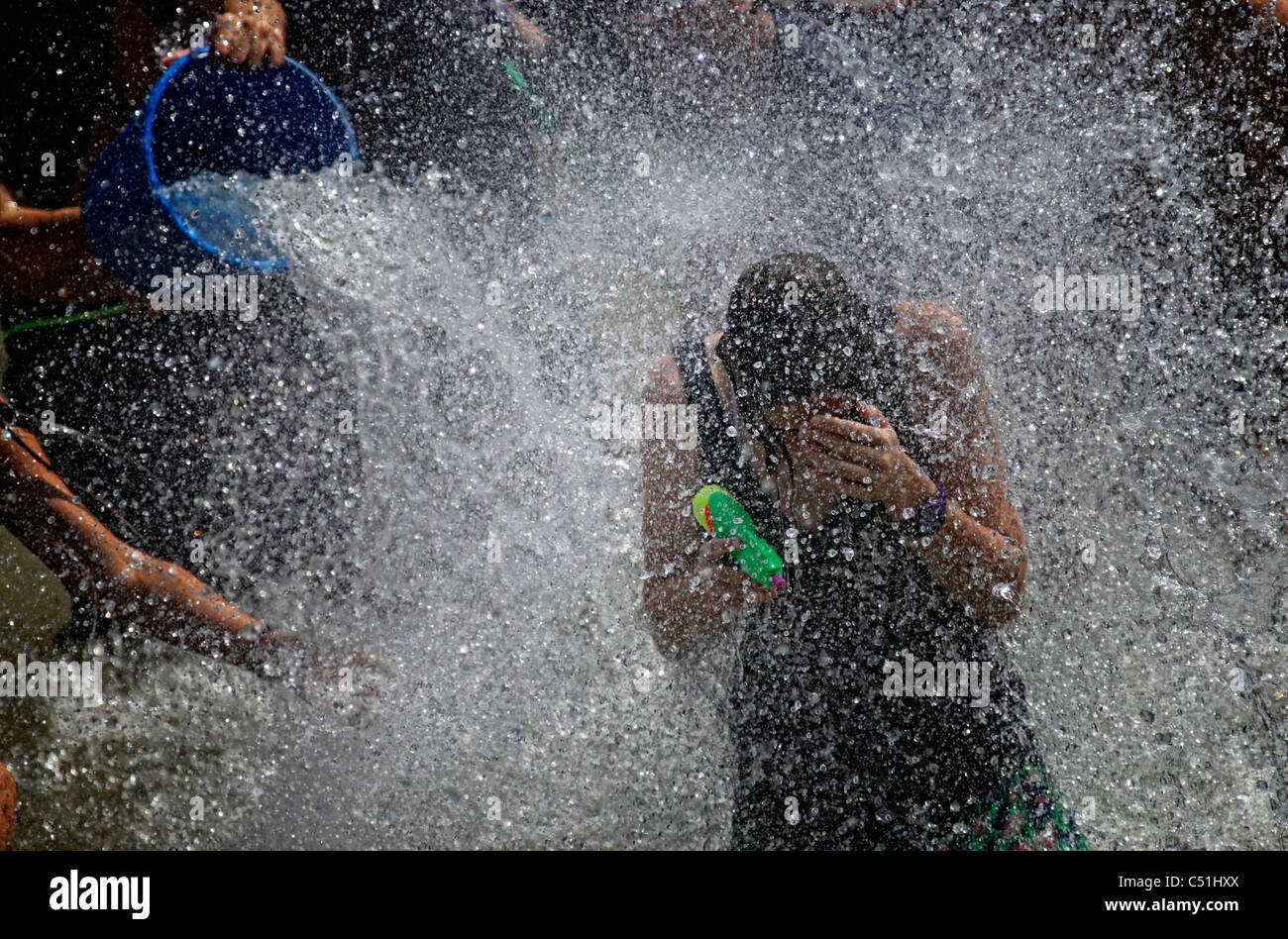 Giovani gaudenti ebraica spry acqua su ogni altro durante l'acqua annuale lotta in Rabin Square nel centro cittadino di Tel Aviv Israele Foto Stock