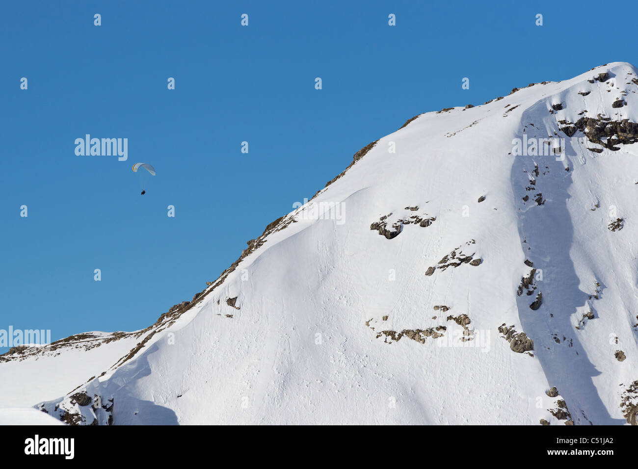 Parapendio su montagne coperte di neve Foto Stock