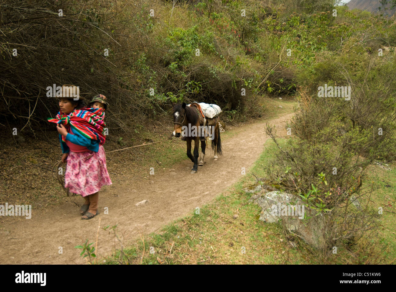 Donna Peruviana con il bambino che conduce a cavallo sul Cammino Inca nella valle Cusichaca Perù Foto Stock